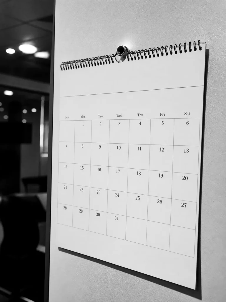 Wandkalender mit geöster Kopflasche an einer Bürowand